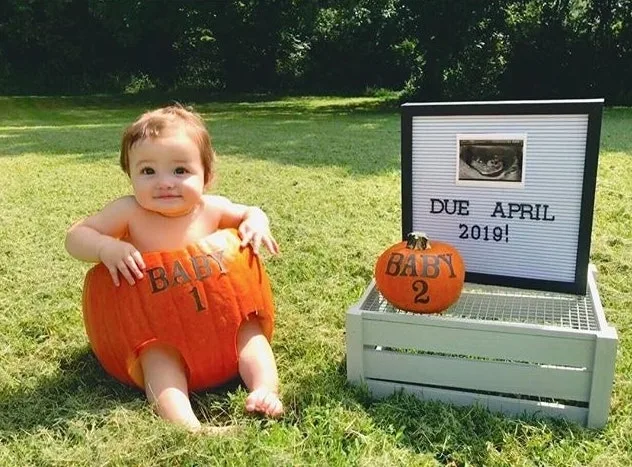 baby in a carved pumpkin for halloween pregnancy announcement