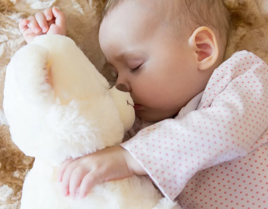 baby sleeping with stuffed animal