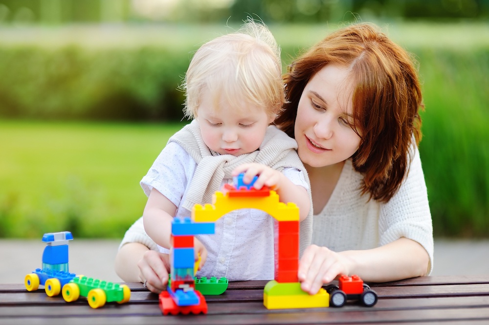 daycare teacher building blocks with child