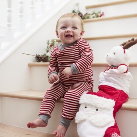 baby with stocking on stairs