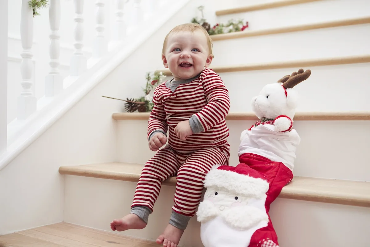 baby with stocking on stairs