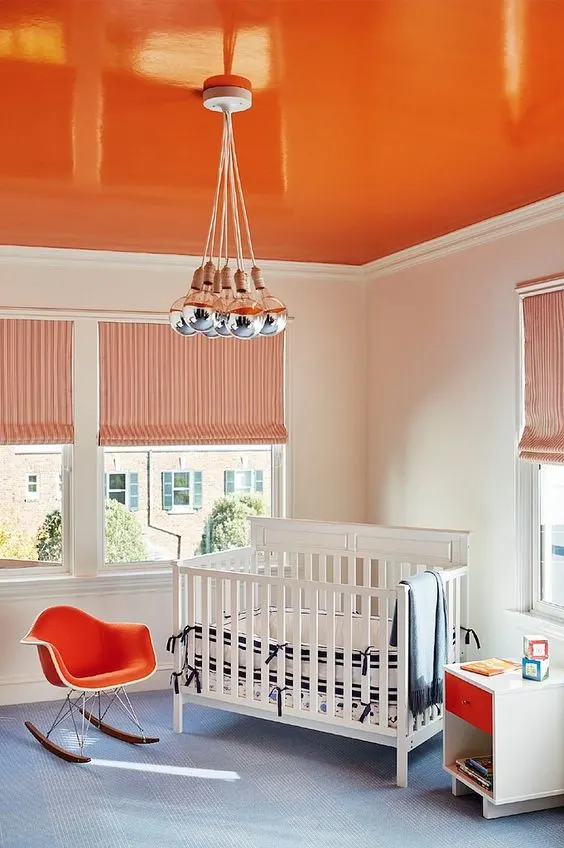 bright orange painted ceiling in baby nursery makes small room look bigger