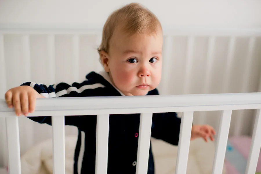 Baby standing in crib during sleep training