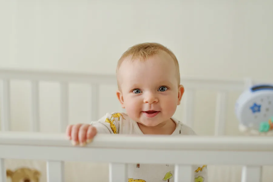 baby starting to stand in crib can disrupt sleep and cause common sleep regressions
