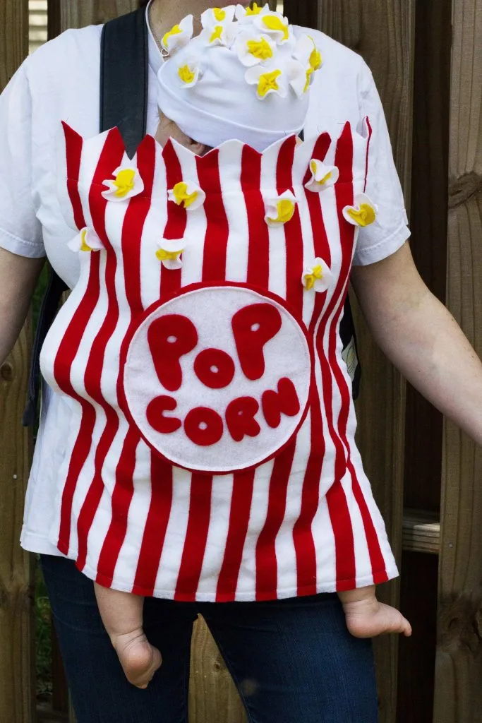 baby in a carrier dressed as popcorn halloween costume