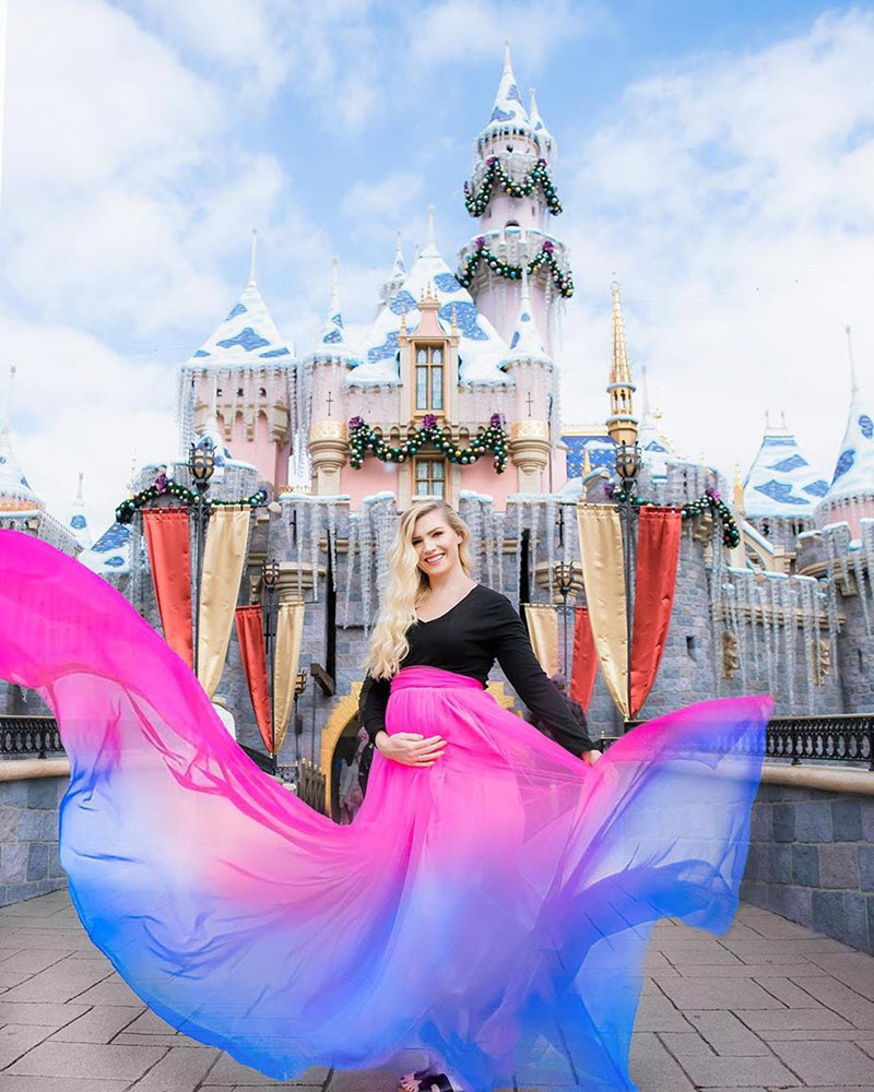 pregnant woman with cololrful skirt in front of Disney castle