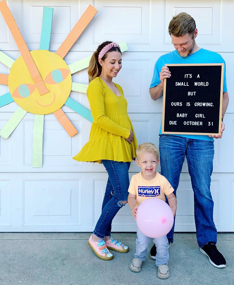 Disney pregnancy announcement - mom, dad, and brother holding a letterboard to announce pregnancy