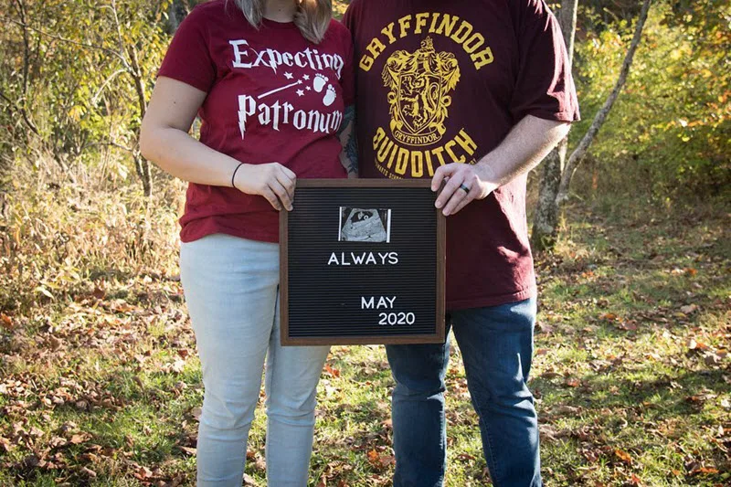 Expectant parents holding Harry Potter Always sign to announce pregnancy