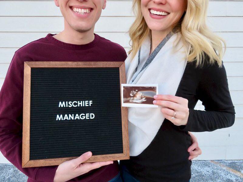 expecting parents  holding a harry potter letter board