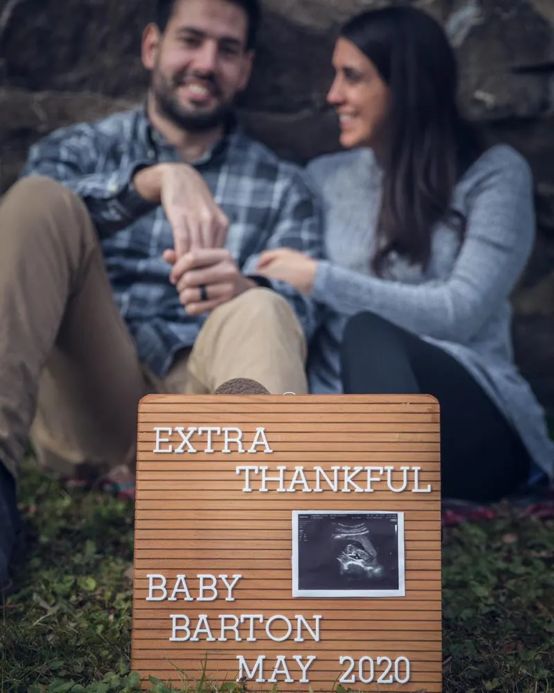 Thanksgiving pregnancy announcement with couple and letter board