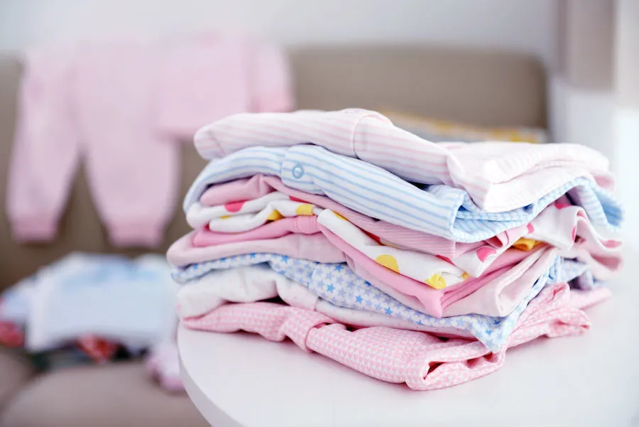 organizing baby clothes into piles