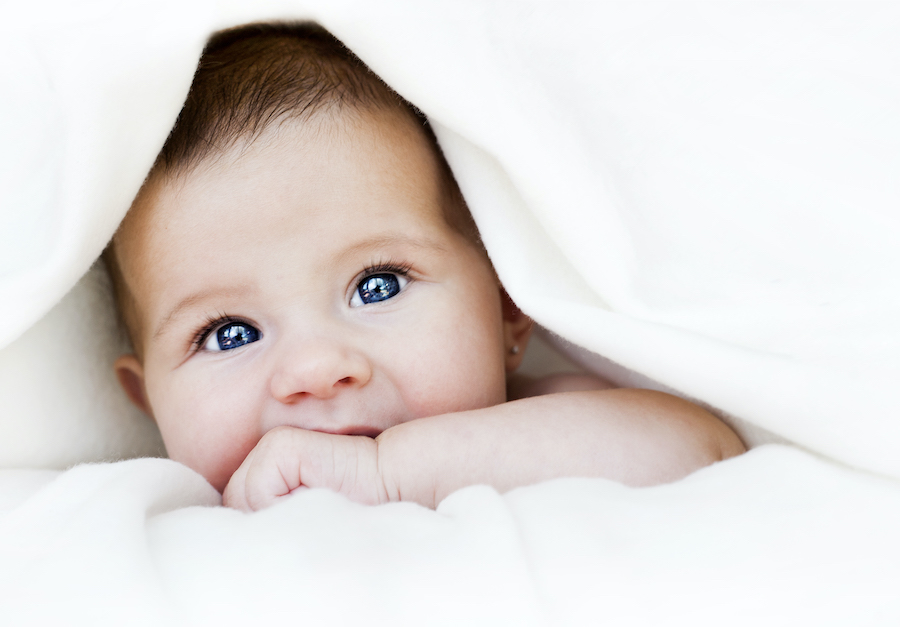 baby's head poking through under a blanket's head poking through under a blanket