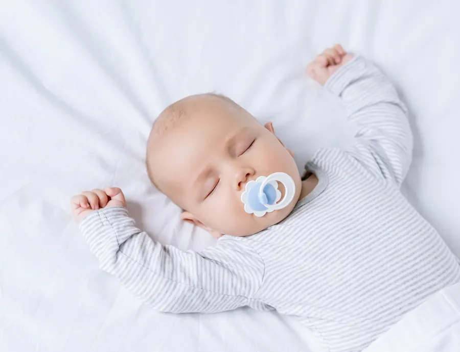 baby sleeping on back with pacifier