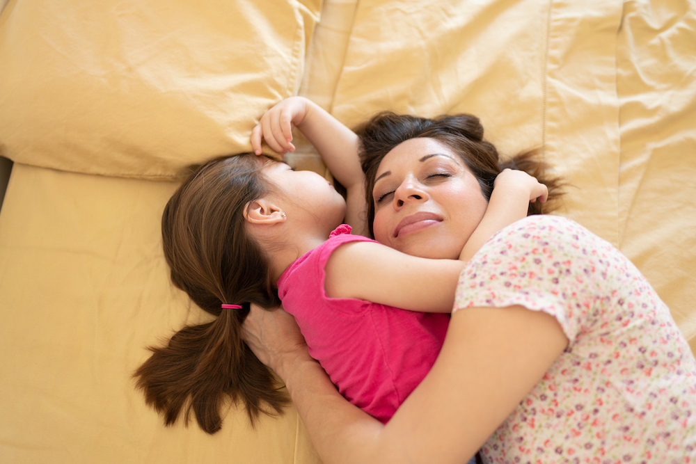 two year old sleep regression, toddler laying with mom