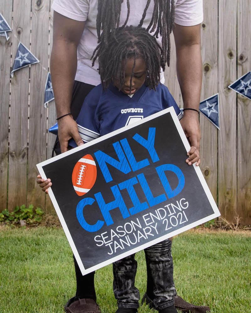 boy holding only child expiring sign with dad