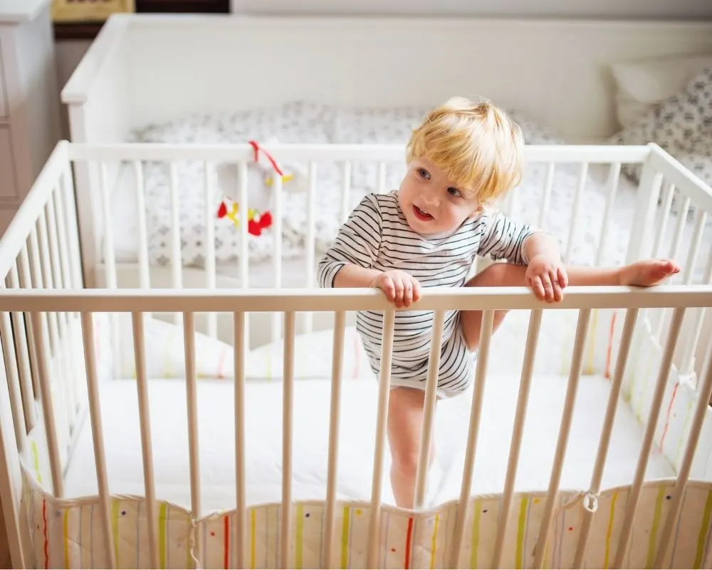 toddler trying to climb out of crib