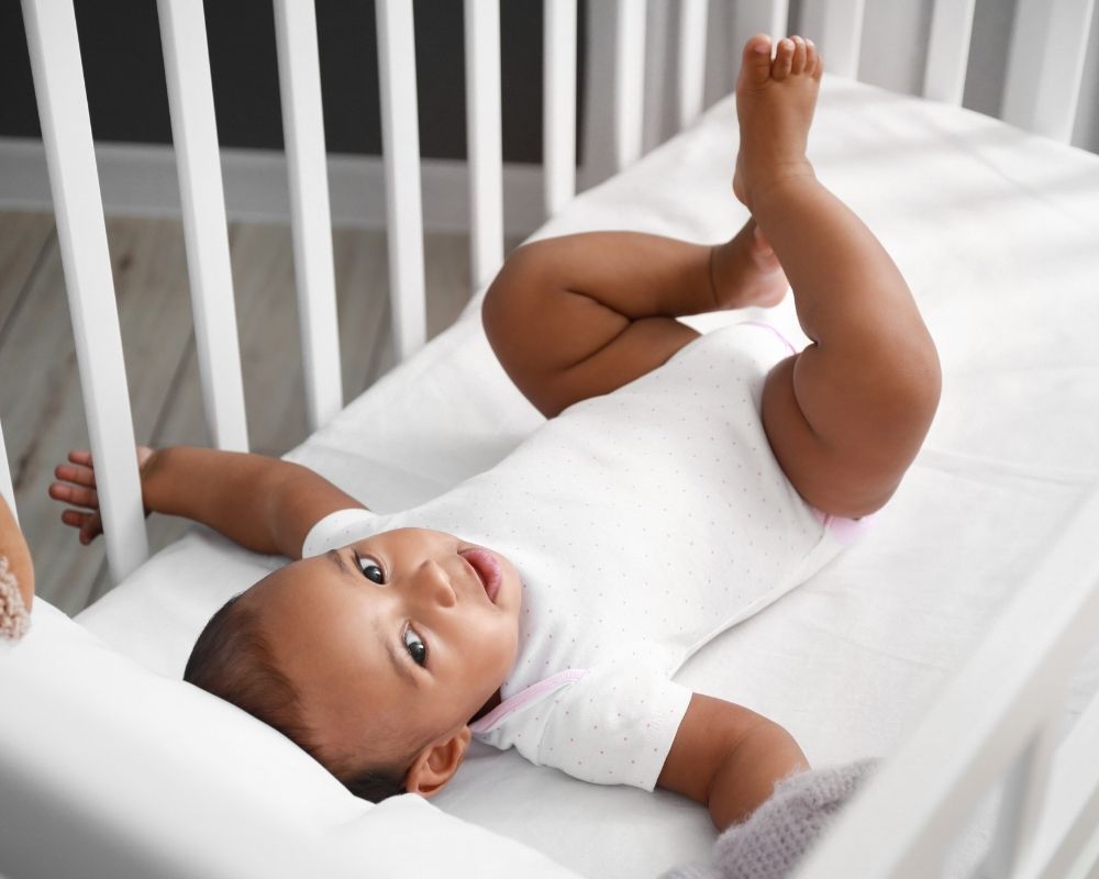 6 month old baby playing in crib