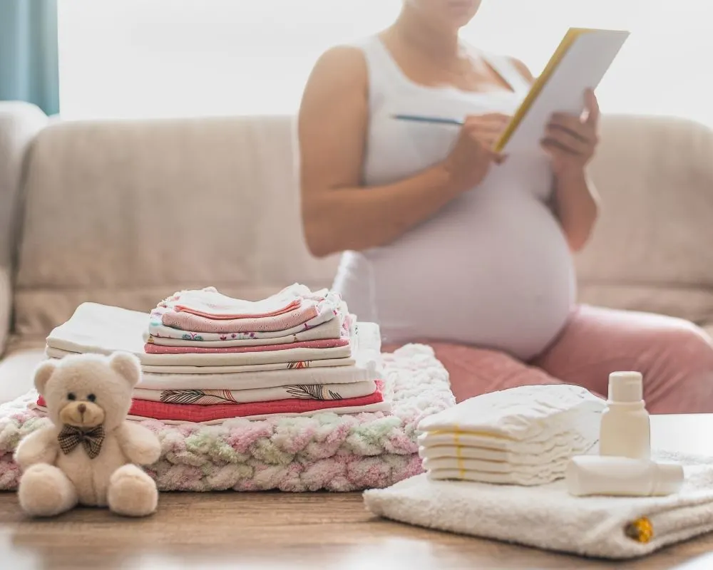 pregnant woman with baby items and a checklist