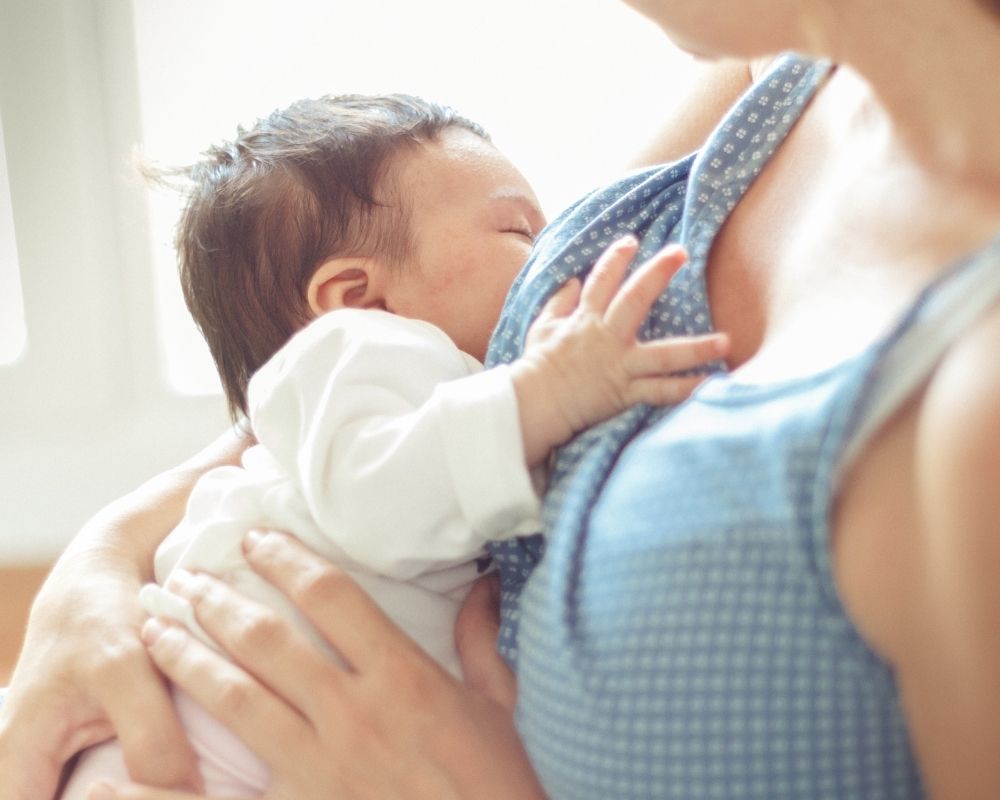 mom nursing baby to sleep