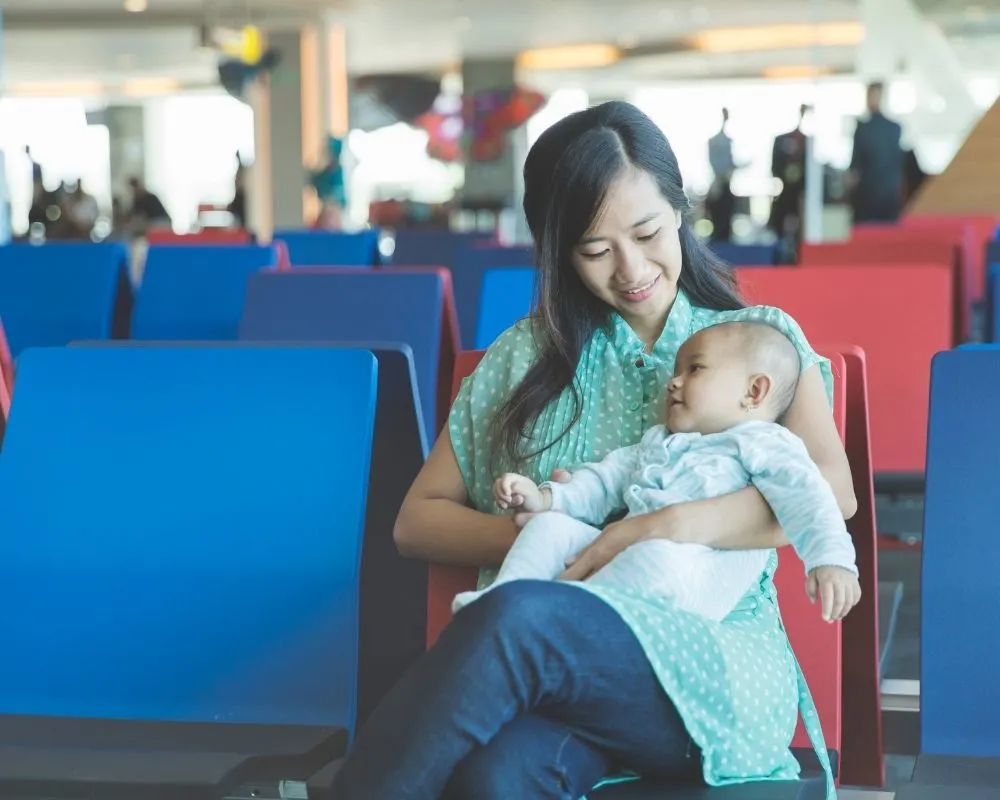 mom traveling with baby sitting at airport