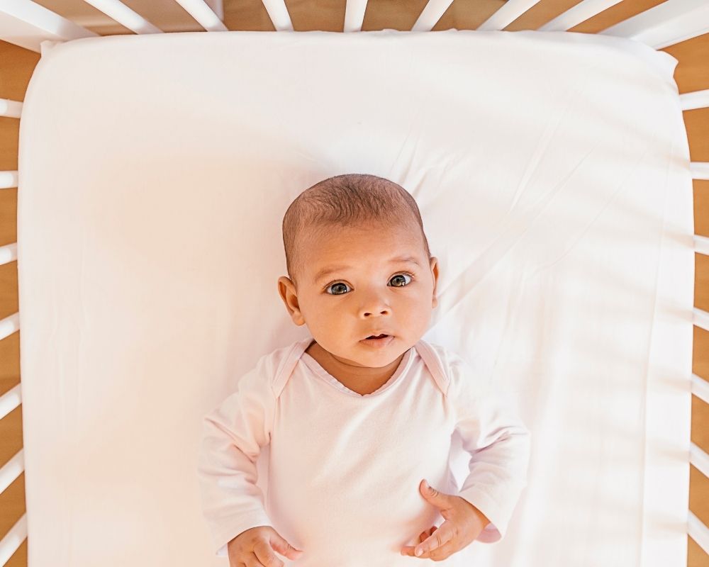 baby awake lying in crib