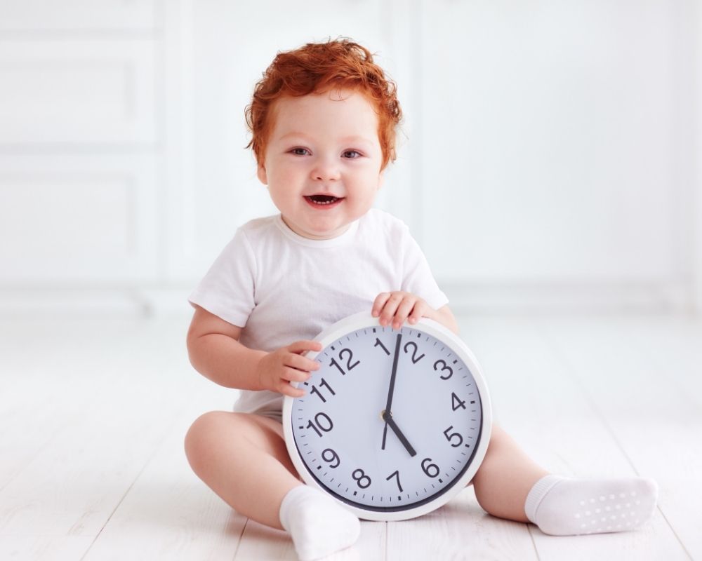 baby holding a clock