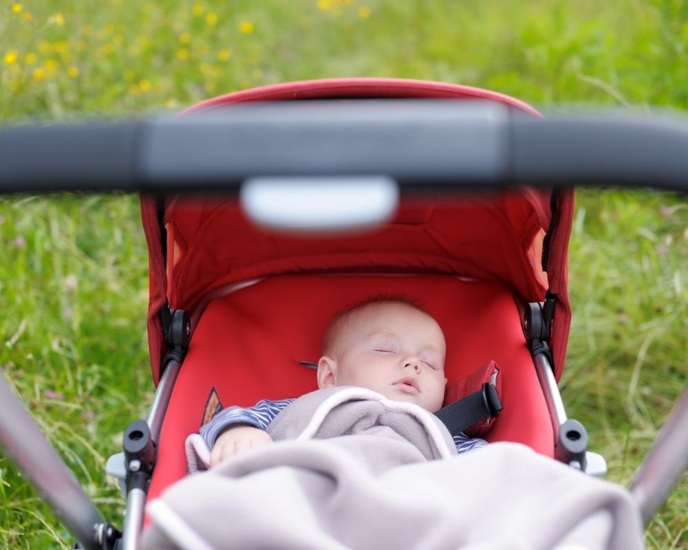 baby sleeping in stroller while traveling