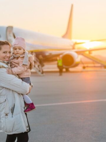 mom and baby in front of airplane