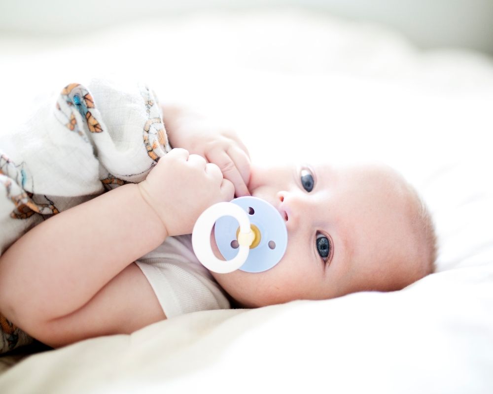 baby laying down sucking on pacifier