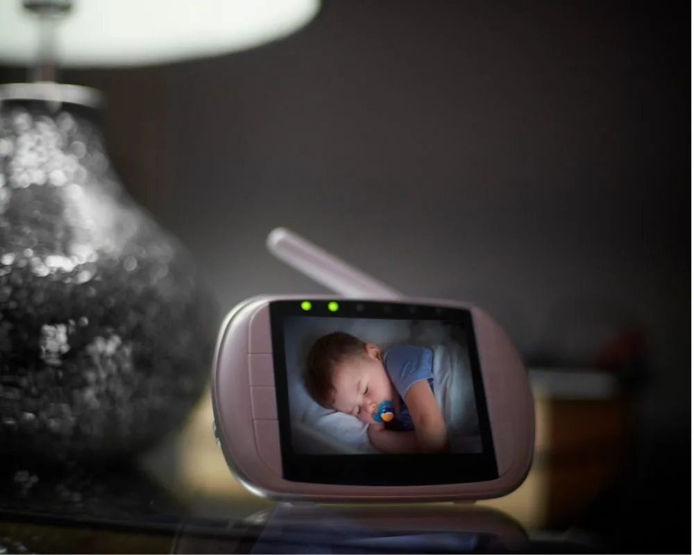 Toddler asleep with pacifier on baby monitor