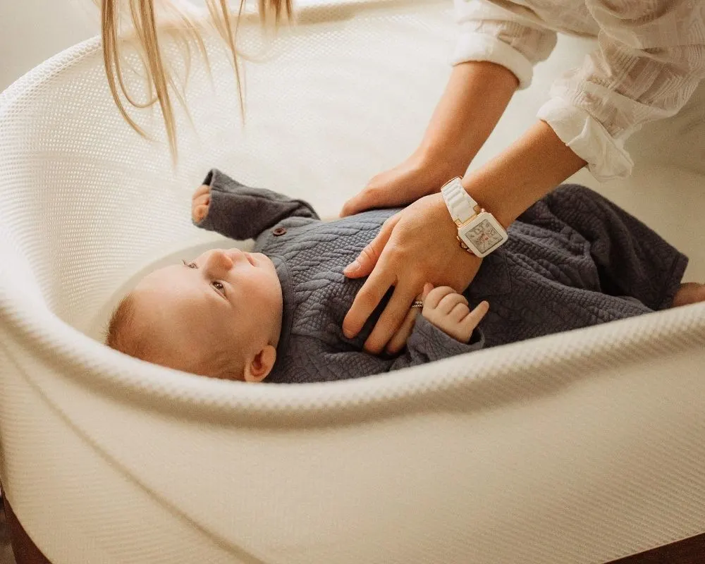 mom putting baby in SNOO bassinet