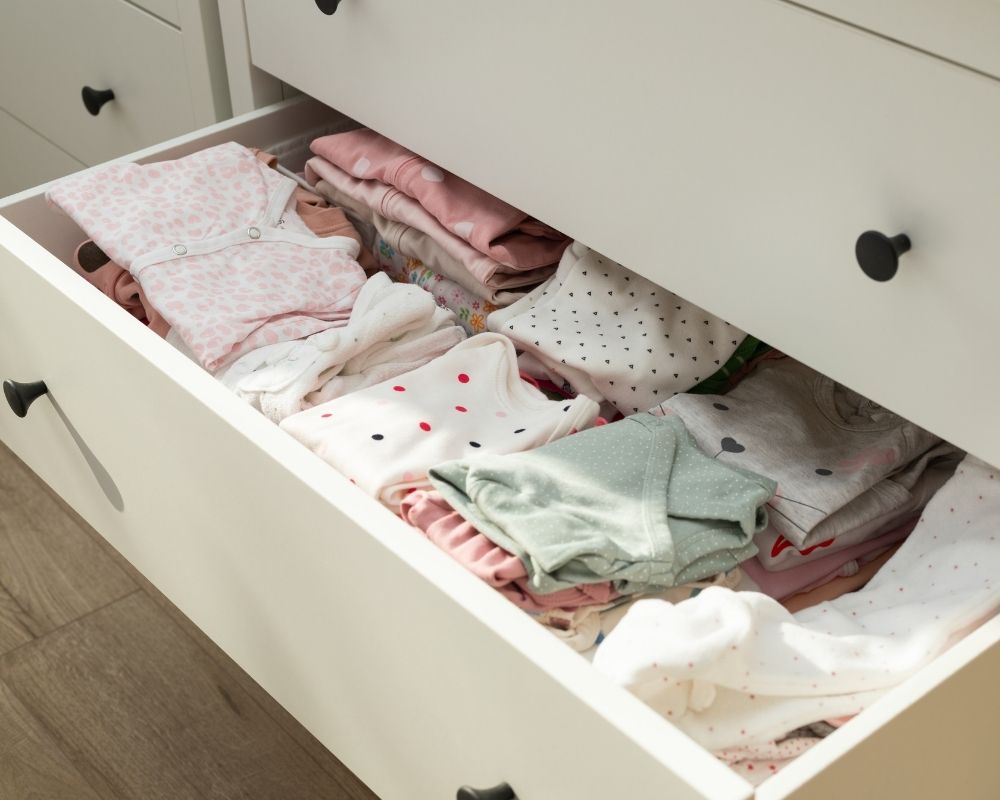 baby's clothes in dresser