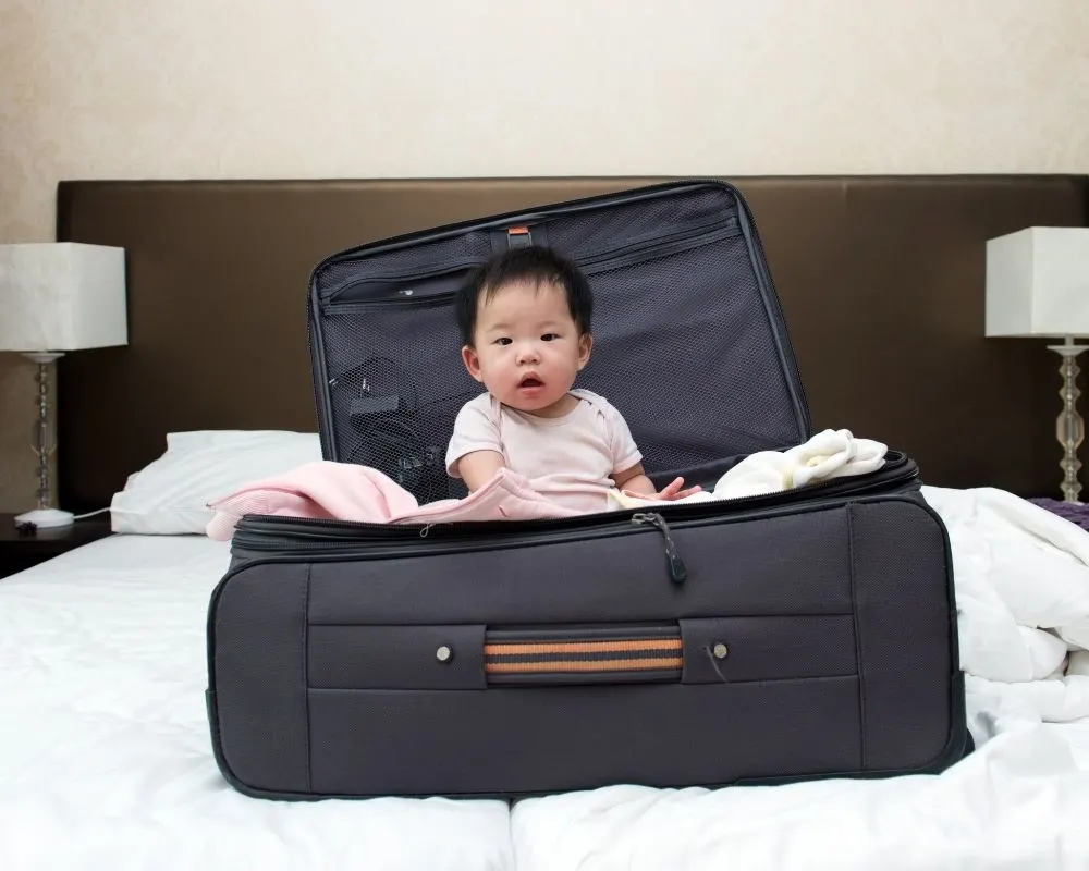 baby in a suitcase on bed