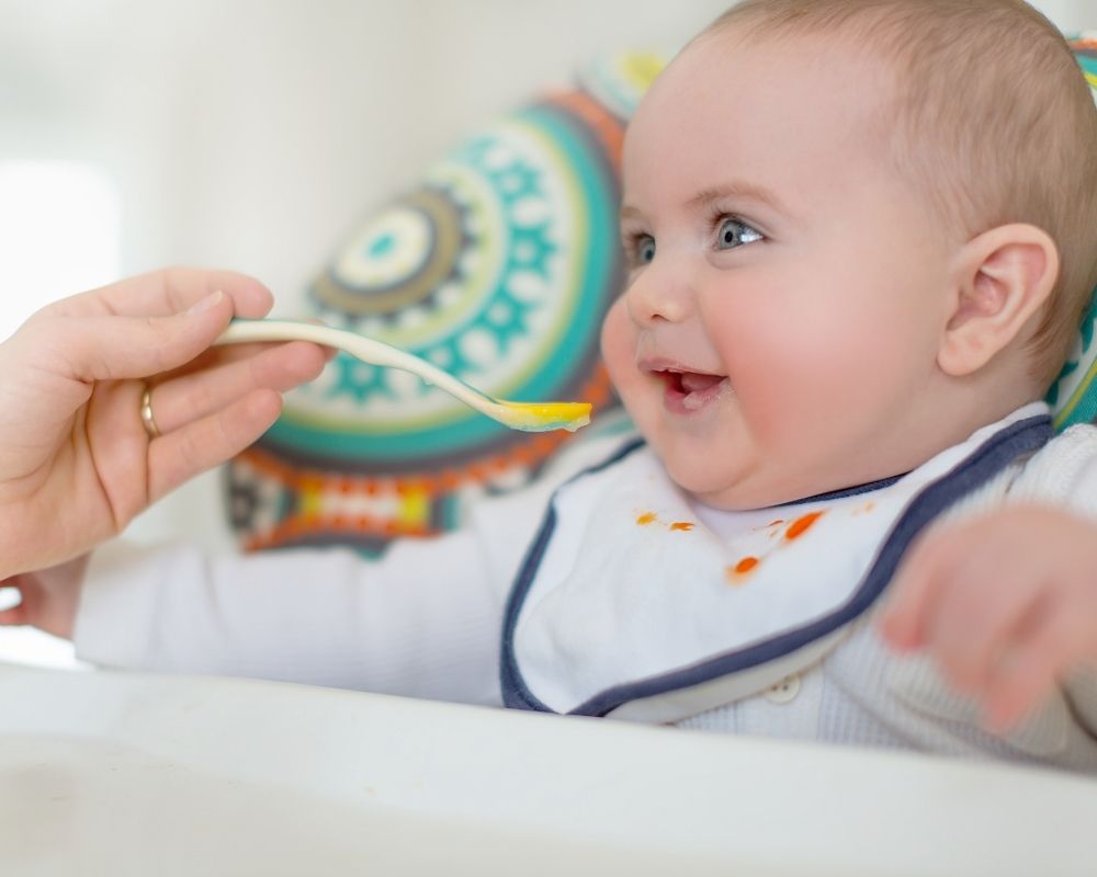 baby led weaning vs purees: baby being spoon fed