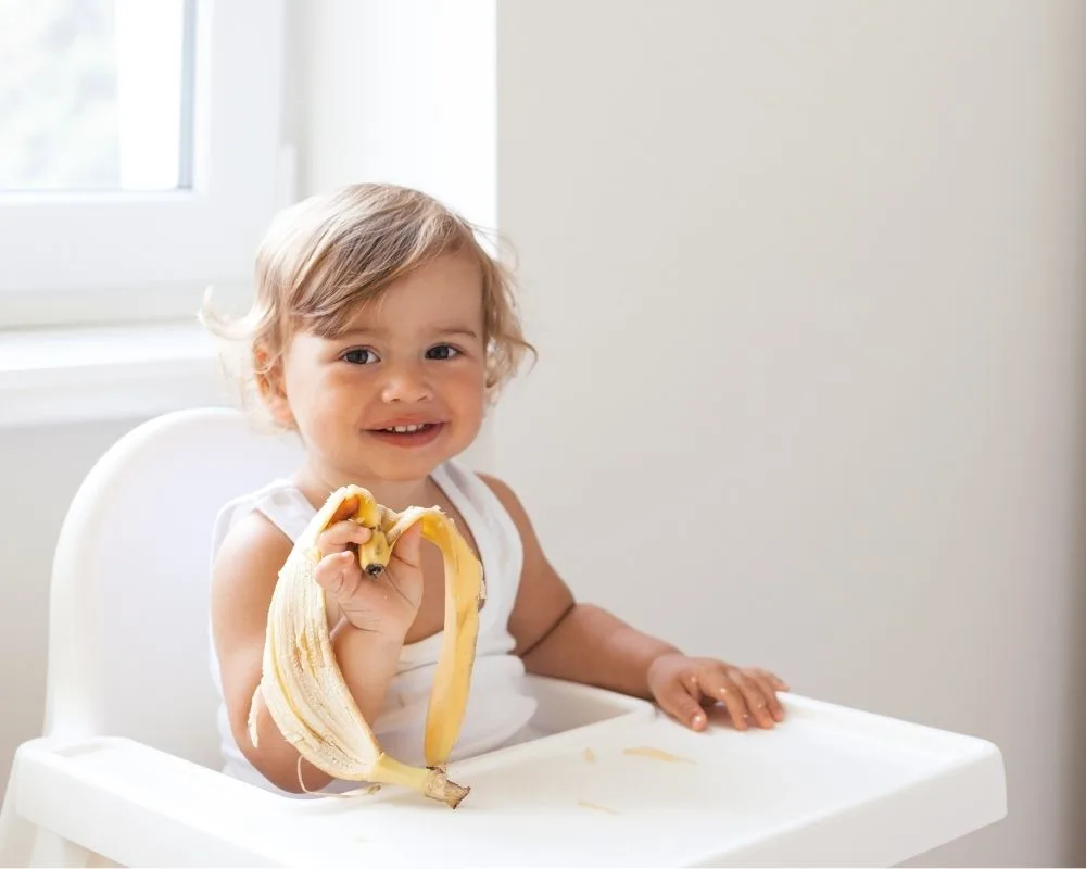 baby girl eating a banana 