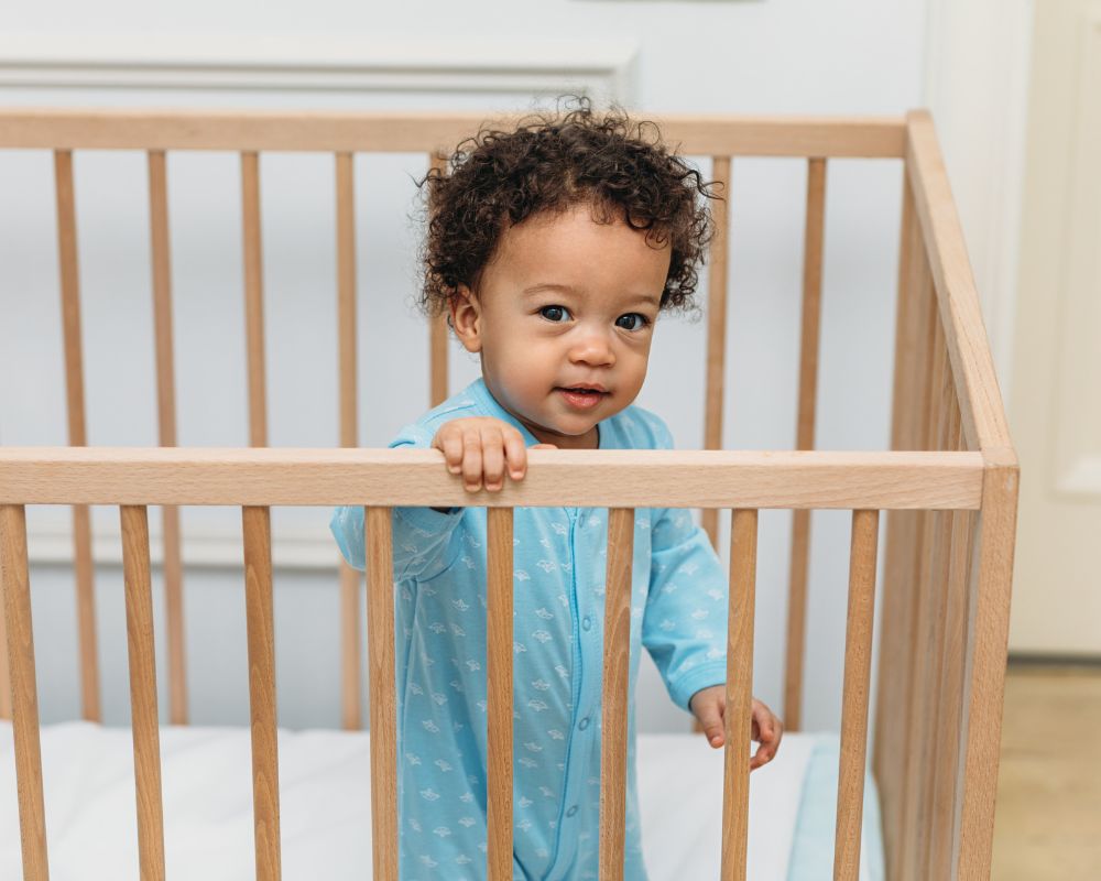 toddler boy standing up in crib