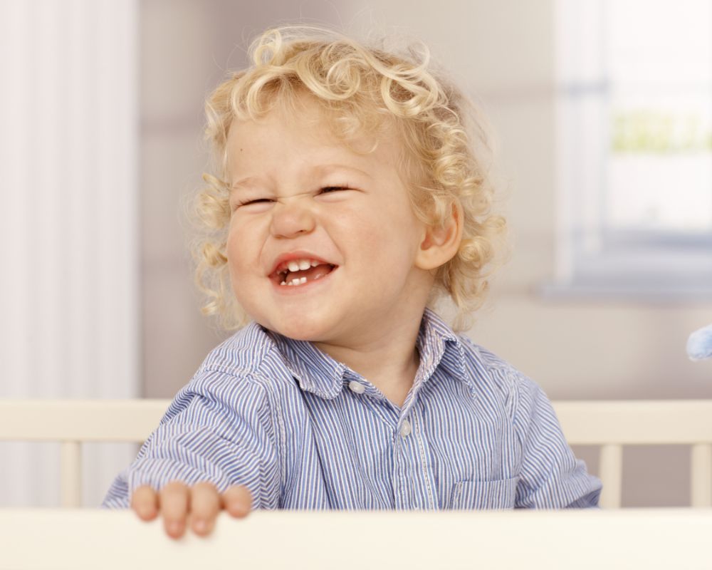 toddler boy standing up in crib