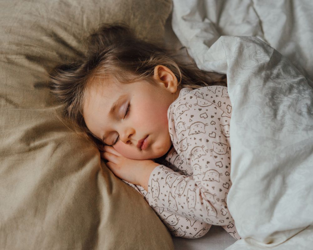 toddler girl asleep in bed