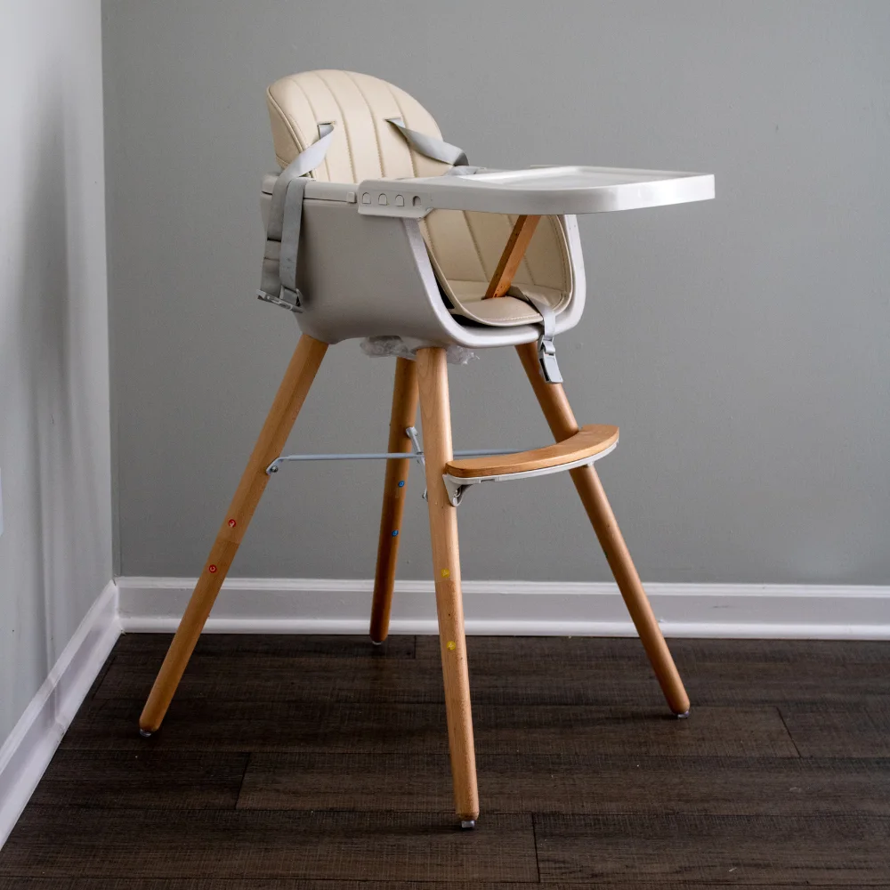 an empty cream and gray high chair