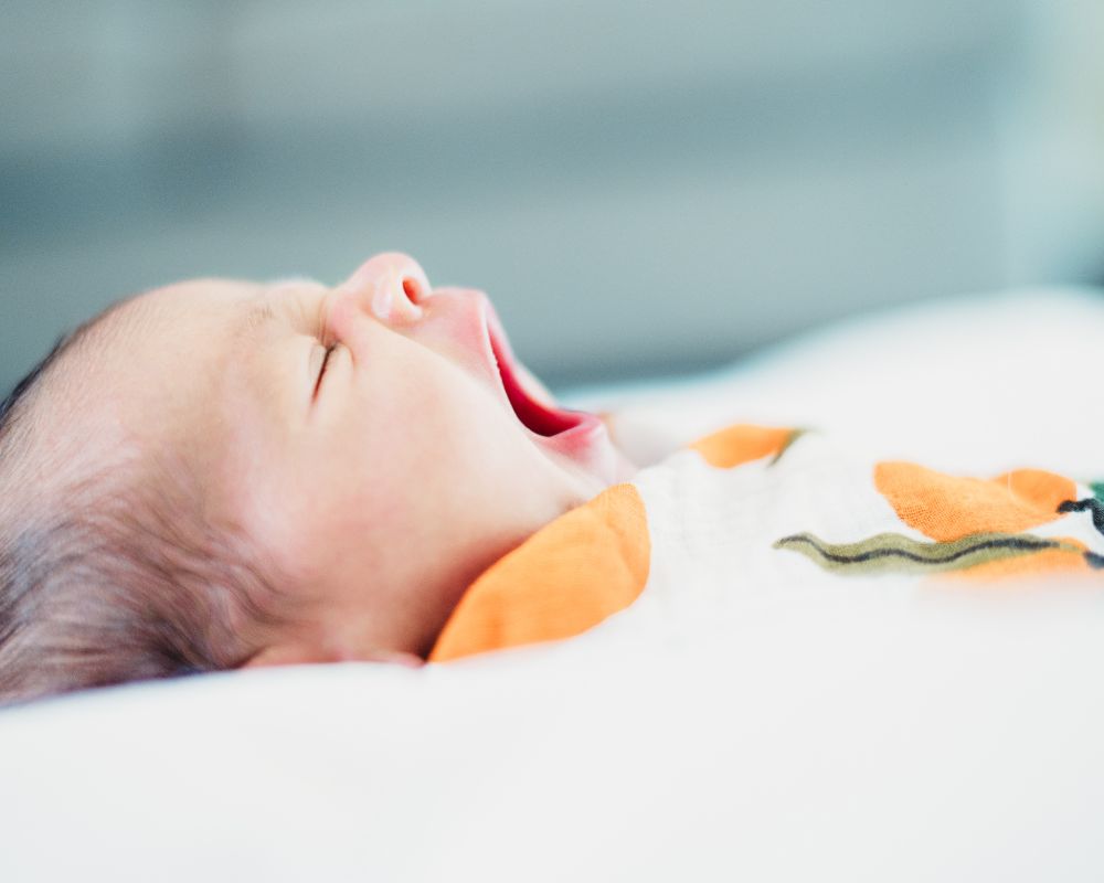 newborn yawning in a swaddle