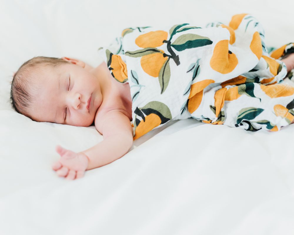 sleeping infant that has broken out of the swaddle