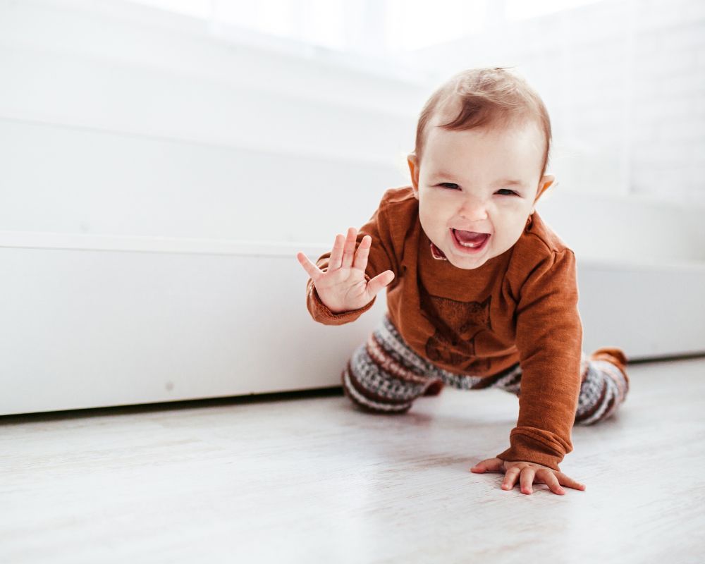 smiling baby crawling on floor