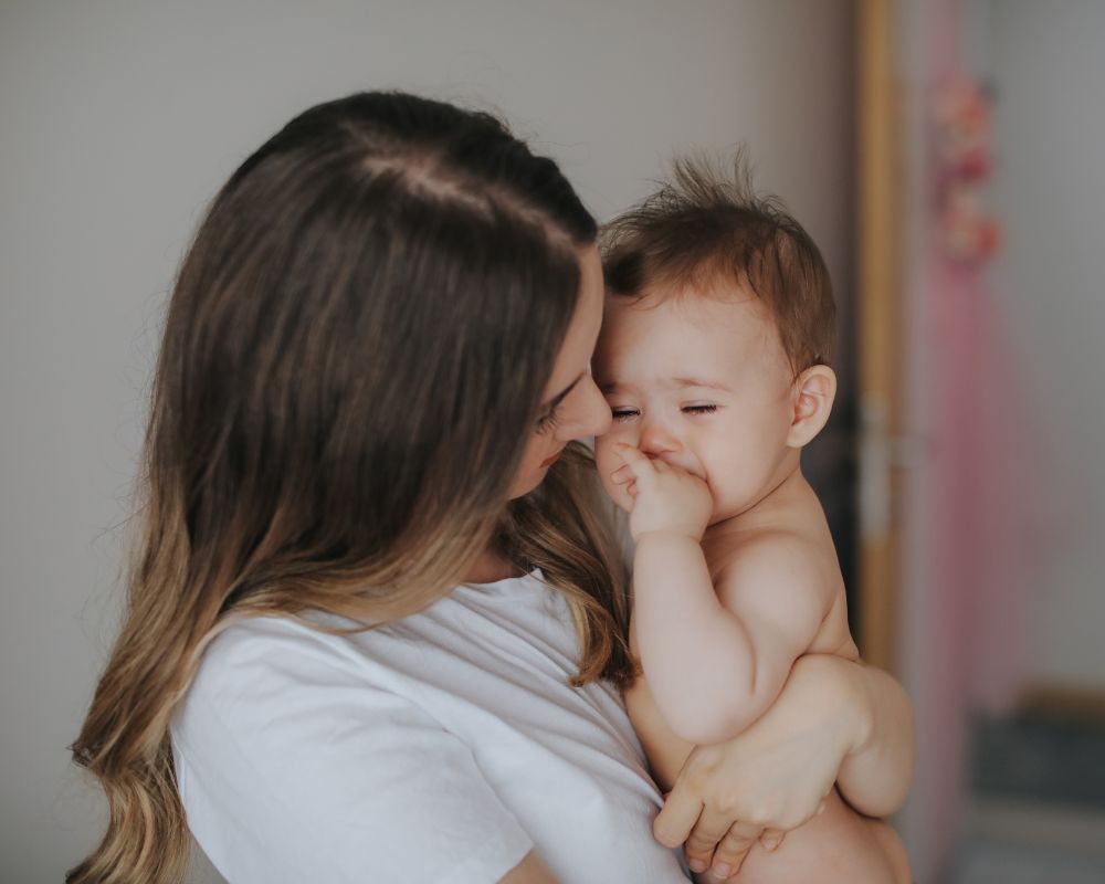 Mother holding her fussy baby at nap time image