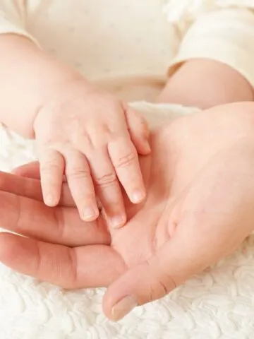 Picture of baby's hand held in parent's hand