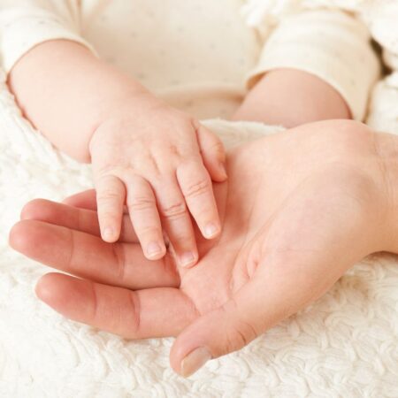 Picture of baby's hand held in parent's hand