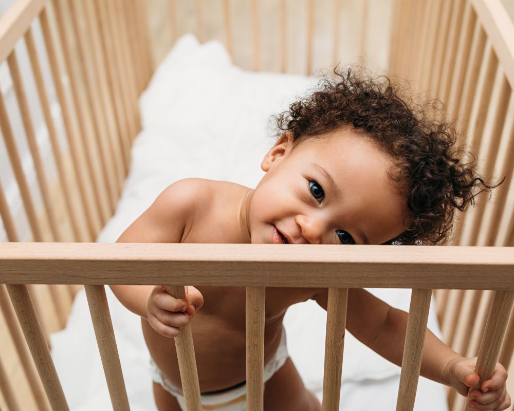 image of baby awake and standing in crib