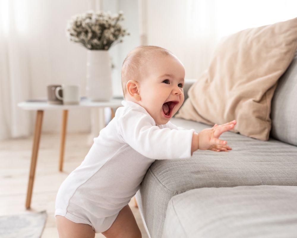image of 10 month old smiling and pulling up to stand