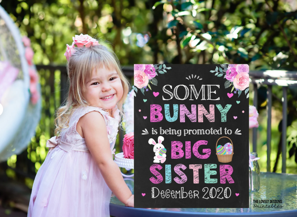 little girl announcing she's going to be a big sister with an Easter theme sign