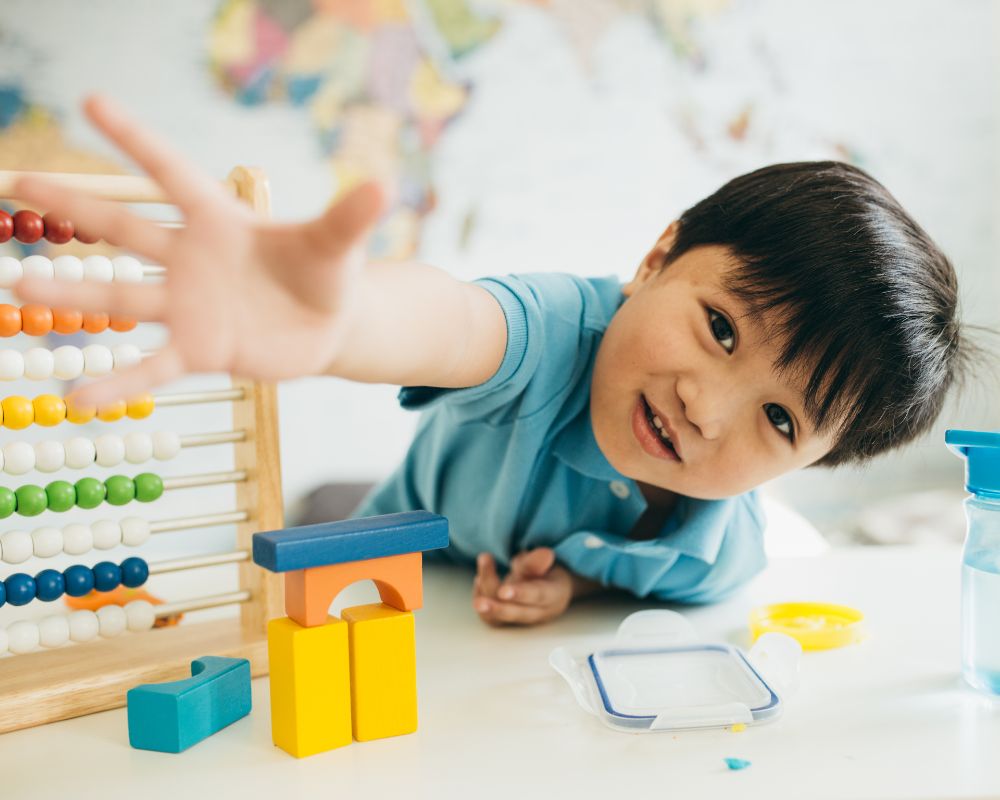 image of toddler playing with toys and reaching towards the camera