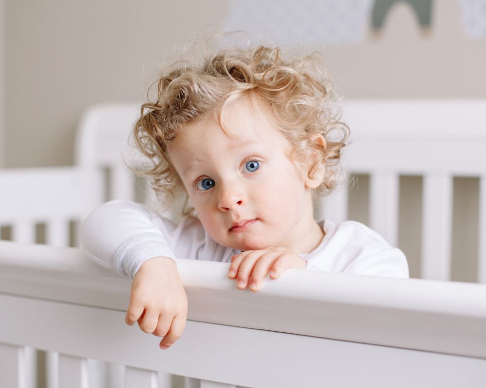 image of toddler standing awake in their crib